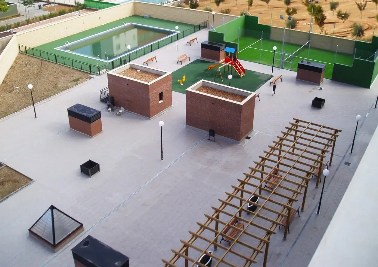 Vista aérea de un condominio vivienda con piscina, zona infantil, cancha deportiva y pérgola.
