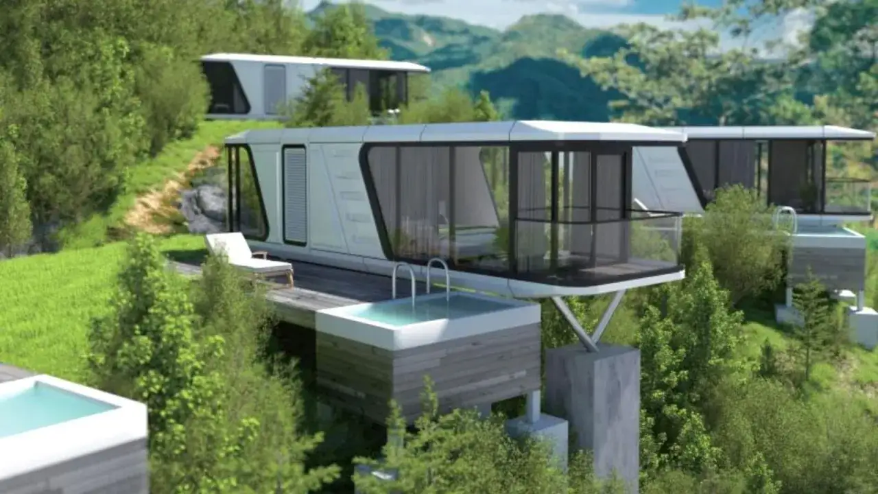Vistas de una casa cápsula moderna con piscina privada en una ladera verde, rodeada de árboles y montañas.