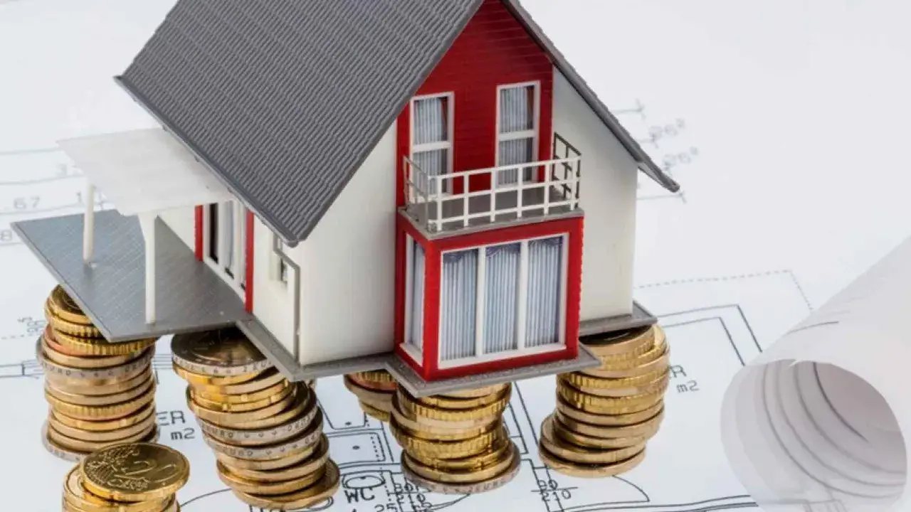 Casa modelo sobre pilas de monedas, simbolizando el costo de una cuenta vivienda.
