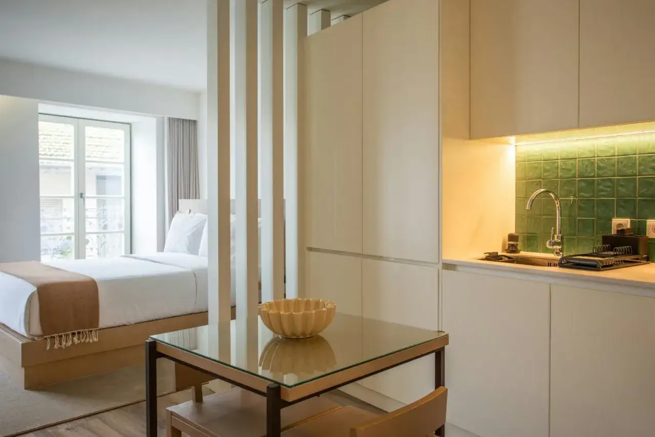 Modernos apartamentos o estudios con cama, cocina y mesa de cristal.