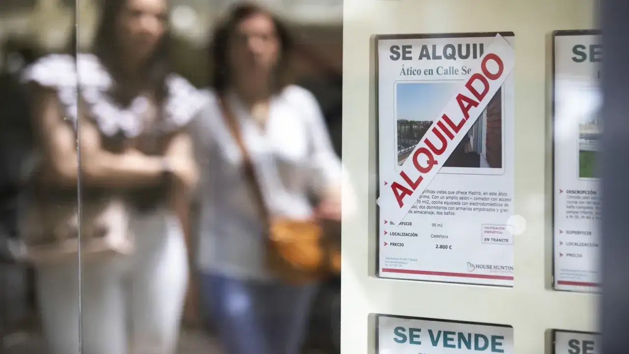 Reflejo de personas mirando un cartel de 