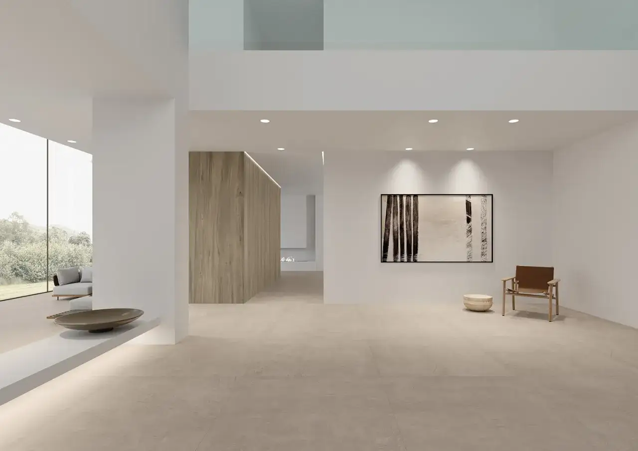 Amplio salón moderno con suelo de baldosas de tonos neutros, que muestra diferentes tipos de suelos. Muebles minimalistas y arte en la pared.