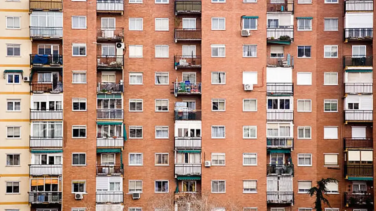Fachada de edificio de ladrillo visto con múltiples balcones y ventanas. Se aprecia el pleno dominio de la arquitectura urbana.