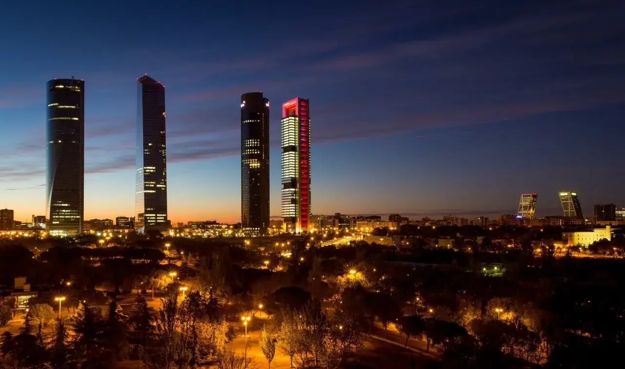 Edificios iluminados en Madrid al anochecer. Un paisaje urbano perfecto para rellenar modelo 600 Comunidad de Madrid.